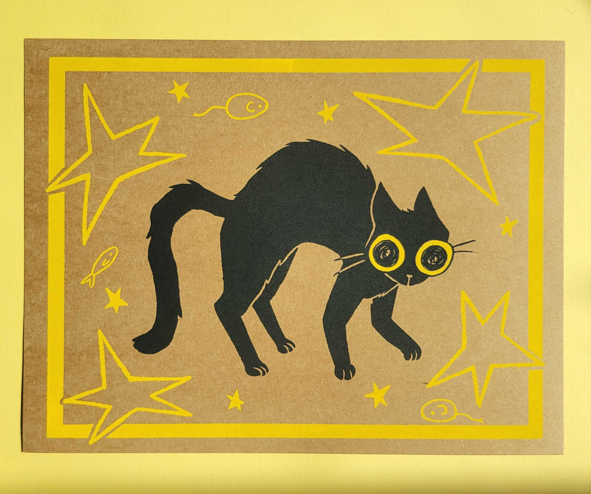 A black cat with yellow eyes on a brown background surrounded by stars and toys